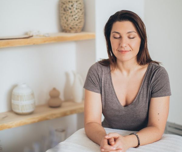 Person smiling peacefully in a serene environment, suggesting well-being and mental clarity.